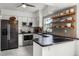 Modern kitchen featuring stainless steel appliances, light gray cabinets, black countertops, and an eat-in peninsula at 530 Eastlake Dr, Haines City, FL 33844