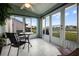 Enclosed lanai with tile flooring, offering serene outdoor views of the pond and neighborhood at 530 Eastlake Dr, Haines City, FL 33844