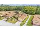 Aerial view of a well-maintained home with lush greenery, landscaping, pond, and a brick-paved driveway at 5341 Hogan Ln, Winter Haven, FL 33884