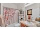 Functional bathroom featuring a shower-tub combo, vanity, and decorative floral accents at 5341 Hogan Ln, Winter Haven, FL 33884