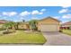 Charming single-story home with a well-manicured lawn, paved driveway, and lush tropical landscaping at 5341 Hogan Ln, Winter Haven, FL 33884
