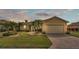Charming single-story home with a well-manicured lawn, paved driveway, and lush tropical landscaping at 5341 Hogan Ln, Winter Haven, FL 33884