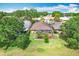 Backyard aerial view featuring a screened lanai, lush lawn, and a well-manicured garden at 571 Saint Andrews Rd, Winter Haven, FL 33884