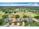 Wide aerial view of a neighborhood with manicured lawns, mature trees, and golf course in the background at 571 Saint Andrews Rd, Winter Haven, FL 33884
