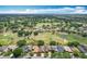 Aerial perspective of a community featuring houses, mature trees, and a sprawling golf course at 571 Saint Andrews Rd, Winter Haven, FL 33884