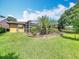 Well-maintained yard featuring a screened-in lanai, lush lawn, and landscaped flower beds at 571 Saint Andrews Rd, Winter Haven, FL 33884