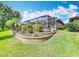 Backyard area with landscaping and view of the screened-in patio, seamlessly blending indoor and outdoor living at 571 Saint Andrews Rd, Winter Haven, FL 33884