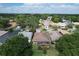 Aerial view of home with screened lanai surrounded by mature trees and a well-manicured lawn at 571 Saint Andrews Rd, Winter Haven, FL 33884
