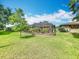 Landscaped backyard with a spacious lawn and a large screened-in lanai at 571 Saint Andrews Rd, Winter Haven, FL 33884