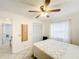 Bright bedroom with tiled floors, a ceiling fan, and white closet doors at 571 Saint Andrews Rd, Winter Haven, FL 33884