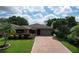 Well-kept home featuring manicured landscaping, a brick driveway, and a two-car garage at 571 Saint Andrews Rd, Winter Haven, FL 33884