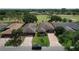 A lovely aerial of the exterior showing the driveway, yard, trees, and roof at 571 Saint Andrews Rd, Winter Haven, FL 33884