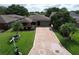 An aerial view of home showing the driveway, garage, yard, and landscaping at 571 Saint Andrews Rd, Winter Haven, FL 33884