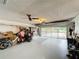 View of a well-lit garage interior with storage, utility sink, and a large overhead door at 571 Saint Andrews Rd, Winter Haven, FL 33884
