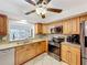Well-equipped kitchen with wood cabinets, granite counters, stainless appliances, and tile floor at 571 Saint Andrews Rd, Winter Haven, FL 33884