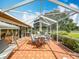 Spacious screened-in patio offering a dining area and relaxing porch swing with tile flooring at 571 Saint Andrews Rd, Winter Haven, FL 33884