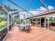 Inviting screened-in patio with tile floors, dining set, and porch swing for outdoor relaxation at 571 Saint Andrews Rd, Winter Haven, FL 33884