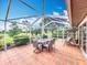 Relaxing screened-in patio features tiled flooring, a dining table, and a porch swing for outdoor enjoyment at 571 Saint Andrews Rd, Winter Haven, FL 33884