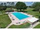 Aerial view of a large community swimming pool with ample seating and surrounding landscape at 571 Saint Andrews Rd, Winter Haven, FL 33884
