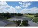 Aerial view of well-maintained tennis courts surrounded by lush greenery in a vibrant community at 571 Saint Andrews Rd, Winter Haven, FL 33884