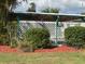 Backyard featuring a covered patio area with mature landscaping and decorative mulch at 6107 Grand Oaks Se Dr, Winter Haven, FL 33884