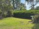Well-maintained backyard features lush green lawn, mature trees, and a decorative bird bath at 6107 Grand Oaks Se Dr, Winter Haven, FL 33884