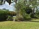 Well-kept backyard with green lawn, mature trees, and a charming bird bath at 6107 Grand Oaks Se Dr, Winter Haven, FL 33884