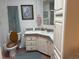 Bathroom featuring a toilet, vanity with a sink, and decorative elements on the walls at 6107 Grand Oaks Se Dr, Winter Haven, FL 33884
