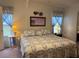 Comfortable bedroom featuring a bed with a patterned comforter, side tables, and blue curtains on the windows at 6107 Grand Oaks Se Dr, Winter Haven, FL 33884