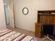 Bedroom with a wooden desk and chair, a round mirror, and a bed with a floral patterned comforter at 6107 Grand Oaks Se Dr, Winter Haven, FL 33884