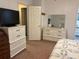 Bedroom with a TV on a dresser and a white dresser with a mirror in front of a door at 6107 Grand Oaks Se Dr, Winter Haven, FL 33884