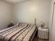 Bedroom with a white wicker headboard and a bed with a colorful patterned comforter, illuminated by bedside lamps at 6107 Grand Oaks Se Dr, Winter Haven, FL 33884