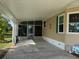 Carport with screened room featuring a back door entry and exterior decor accents and a well manicured lawn at 6107 Grand Oaks Se Dr, Winter Haven, FL 33884