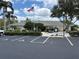 Community building with parking spots, an American flag, and lush landscaping at 6107 Grand Oaks Se Dr, Winter Haven, FL 33884