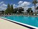 Outdoor community pool surrounded by lounge chairs and lush landscaping at 6107 Grand Oaks Se Dr, Winter Haven, FL 33884