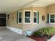 Exterior corner showcasing a window arrangement with green shutters and a small garden bed at the base at 6107 Grand Oaks Se Dr, Winter Haven, FL 33884
