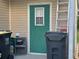 Exterior side door, ladder, and trash receptacles showing the utility access point to the home at 6107 Grand Oaks Se Dr, Winter Haven, FL 33884