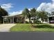Charming single-story home with well-manicured lawn, lush landscaping, carport, and welcoming curb appeal at 6107 Grand Oaks Se Dr, Winter Haven, FL 33884