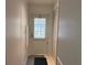 Hallway with a door leading outside and closet, with neutral wall color at 6107 Grand Oaks Se Dr, Winter Haven, FL 33884