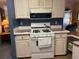 Functional kitchen space including white cabinets, a stove, and plenty of counter space and overhead ventilation at 6107 Grand Oaks Se Dr, Winter Haven, FL 33884