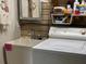 Laundry room featuring a utility sink, an adjacent laundry machine, and a mirror at 6107 Grand Oaks Se Dr, Winter Haven, FL 33884
