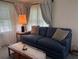 Comfortable living room with a blue sofa, decorative curtains, and natural light at 6107 Grand Oaks Se Dr, Winter Haven, FL 33884