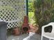 Back patio with white lattice fence, chimenea, potted plants, and lush greenery surrounding the space at 6107 Grand Oaks Se Dr, Winter Haven, FL 33884