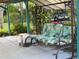 Patio featuring a swing bench with colorful leafy cushions, foliage in the background, and tile flooring at 6107 Grand Oaks Se Dr, Winter Haven, FL 33884