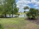 Scenic pond view with a charming bench, fountain, lush lawn, and clear blue sky at 6107 Grand Oaks Se Dr, Winter Haven, FL 33884