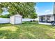Backyard featuring a shed, patio, fence, and green lawn at 612 Ralph St, Auburndale, FL 33823