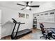 Bright bedroom with a treadmill, gaming chair, sports memorabilia, and wood flooring at 612 Ralph St, Auburndale, FL 33823