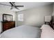 Comfortable bedroom featuring a ceiling fan, a dresser with a mirror, and a window for natural light at 612 Ralph St, Auburndale, FL 33823