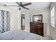 Comfortable bedroom featuring a ceiling fan, a dresser with a mirror, and a window for natural light at 612 Ralph St, Auburndale, FL 33823