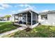 Enclosed patio with furniture and a walkway leading to a green lawn at 612 Ralph St, Auburndale, FL 33823
